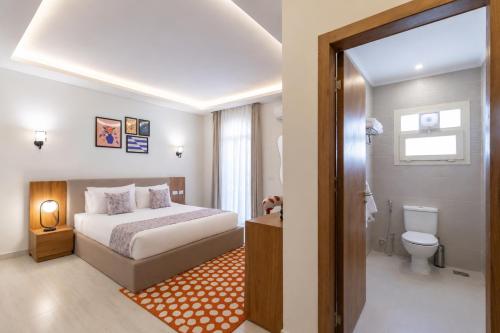 a hotel room with a bed and a toilet at Seven Stays Centric West Zayed in Sheikh Zayed