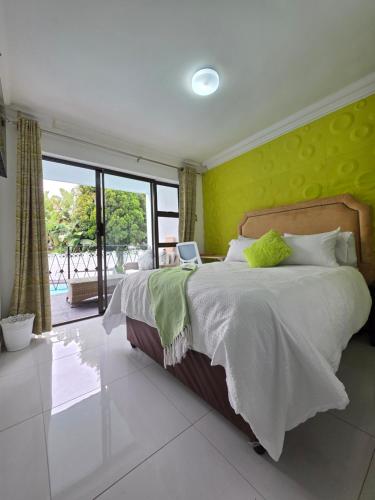 a bedroom with a large bed with a yellow wall at Sbukosezwe guest house in Johannesburg