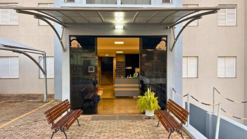 two benches sitting in front of a building at Ribs Hotel in Piauí
