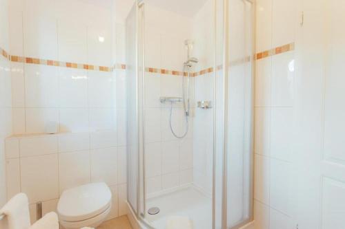 a white bathroom with a shower and a toilet at Chalet SOLYMONT by MoniCare in Seefeld in Tirol