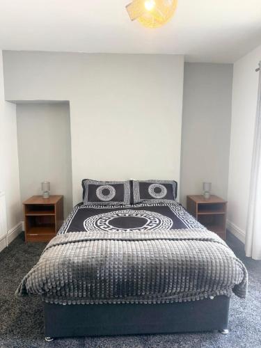 a bedroom with a bed with a black and white comforter at Premium Bedroom Escape in Hull