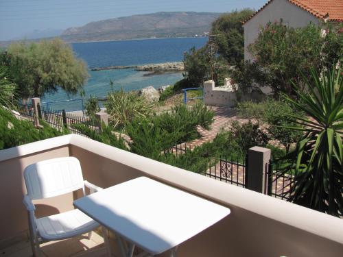 a balcony with a table and chairs and a view of the water at Lakonia Bay Apartments in Archangelos