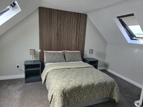 a bedroom with a bed with two night stands and two lamps at Cope House Rooms in Killybegs