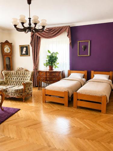 a bedroom with two beds and a purple wall at Astronomical Clock Apartment in Prague
