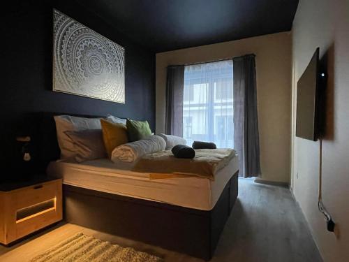 a large bed in a room with a window at Ancram SPA Miskolc in Miskolc