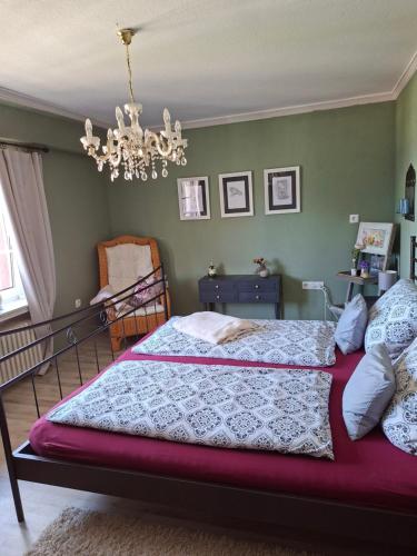 a bedroom with a bed and a chandelier at Fewo Froschkönig in Schieder-Schwalenberg
