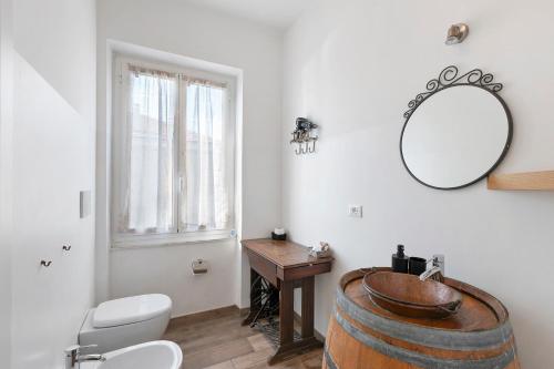a bathroom with a barrel sink and a mirror at Il Leone Bianco Affittacamere in Albenga