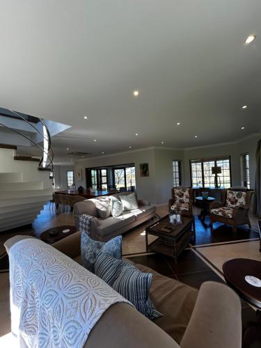 a large living room with couches and chairs at Acacia House in Winterton