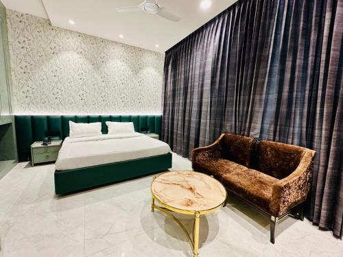 a bedroom with a bed and a chair at hotel fior in Pānīpat