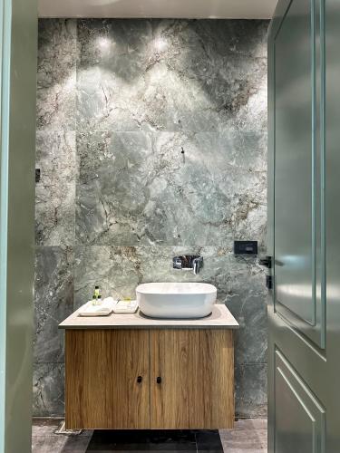 a bathroom with a sink and a stone wall at hotel fior in Pānīpat