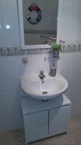 a bathroom sink with a vase of flowers on it at Sunrise Hill Guest House in Los Gallardos