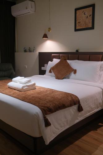 a bedroom with a large bed with towels on it at After Hours Guesthouse Self Check-in in Bangkok