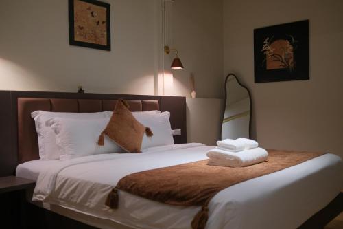a bedroom with a bed with towels on it at After Hours Guesthouse Self Check-in in Bangkok