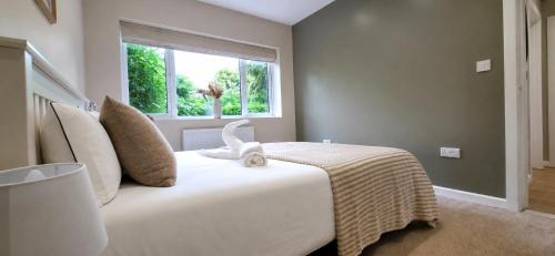 a bedroom with a large white bed with a window at Stoney Lane Cottage in Wakefield
