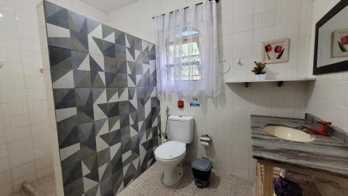 a bathroom with a toilet and a sink at Lar de Nanci e Beto in Arraial do Cabo