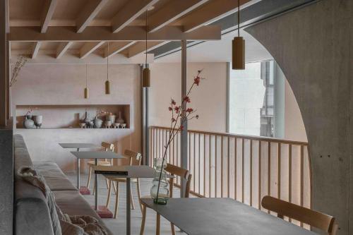 a living room with tables and chairs and a kitchen at Buckle Street Studios by Locke, Aldgate in London