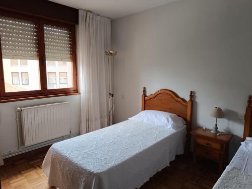 a bedroom with two beds and two windows at Casa Montse-Izquierda in Colombres