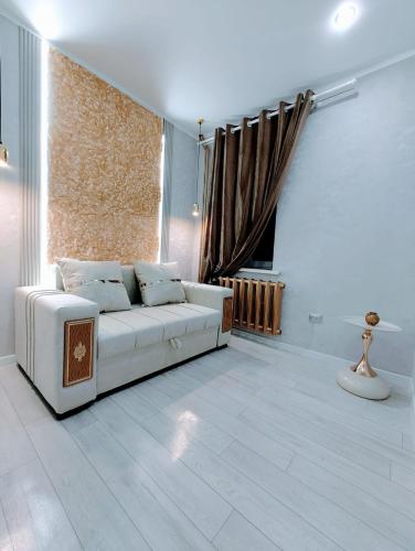 a living room with a white couch and a window at Taraz 2 in Taraz