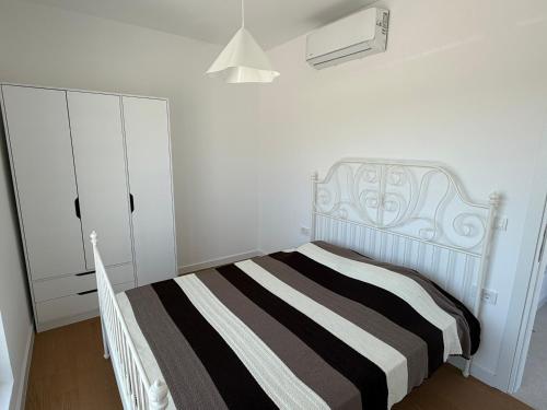 ein weißes Schlafzimmer mit einem Bett und einem weißen Schrank in der Unterkunft Olive Nest in Mrčevac