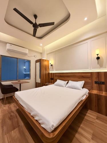 a bedroom with a large bed with a ceiling fan at Rishaan Regency in Silchar