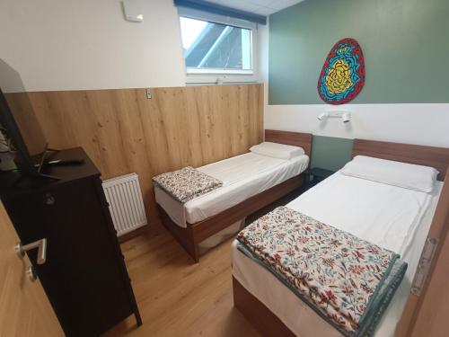 a small room with two beds and a television at Solea Apartment in Woditz