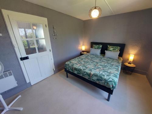 a bedroom with a bed with two lamps and a door at Maison du Grand Moulin in Saint-Aubin-en-Charollais