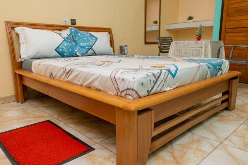 a bed with a wooden frame in a room at Résidence Royale Emma in Abidjan