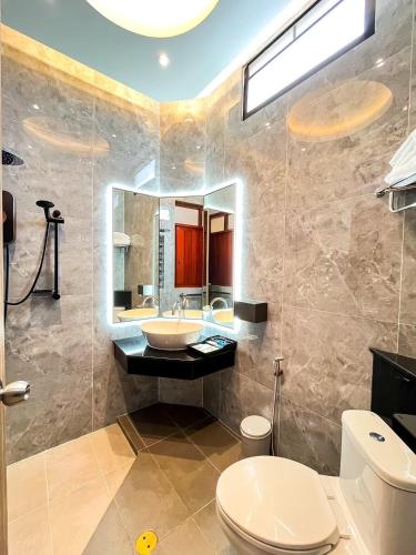 a bathroom with a sink and a toilet and a mirror at เซฟเฮ้าส์ รีสอร์ท in Pattani
