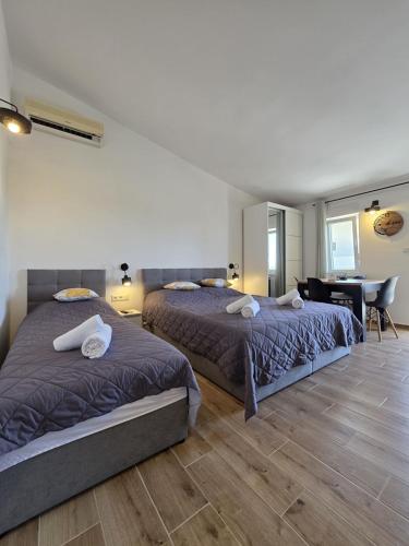 a bedroom with two beds and a desk in it at Apartments Sunce in Podaca