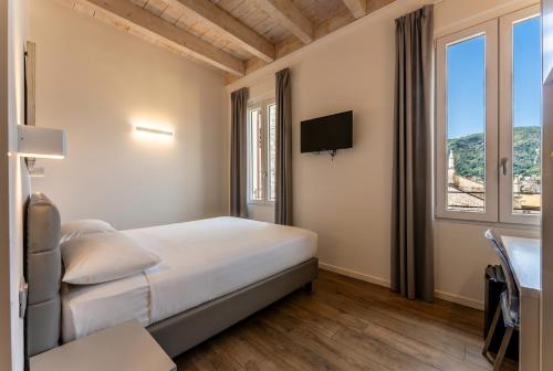 a bedroom with a bed and a desk and a television at Hotel Quarcino in Como