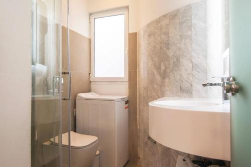 a bathroom with a toilet and a sink and a window at Syntagma Gem 2 in Athens