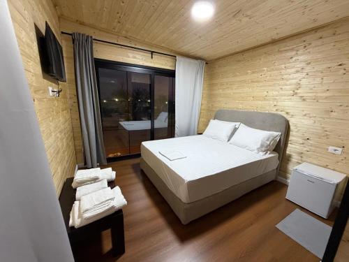 a small bedroom with a bed and a window at Paradise Beachfront Chalet Rooms Borsh in Borsh