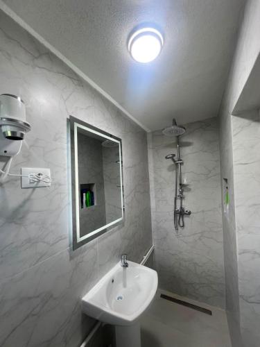 a white bathroom with a sink and a mirror at Albanica Guesthouse in Dacići