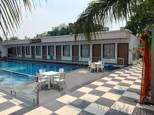 a hotel with a pool and tables and chairs at The Kashi Dharohar in Varanasi