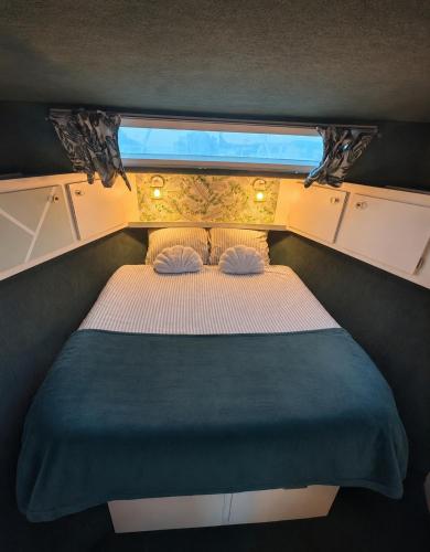 a bed in a small room with a window at Nuit insolite dans un bateau in Le Havre