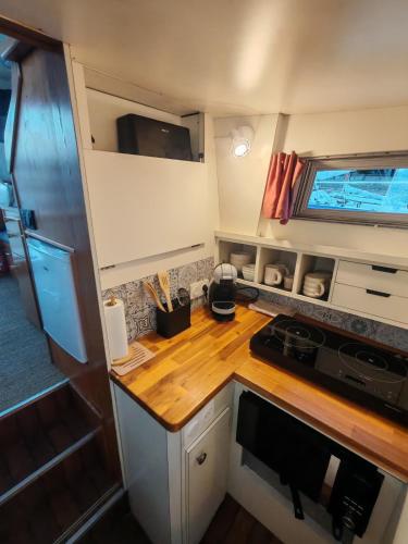 a kitchen with a wooden counter top in a caravan at Nuit insolite dans un bateau in Le Havre