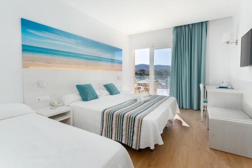 a hotel room with two beds and a window at Hotel Playas de Paguera in Paguera