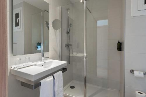 a white bathroom with a sink and a shower at Hotel Playas de Paguera in Paguera