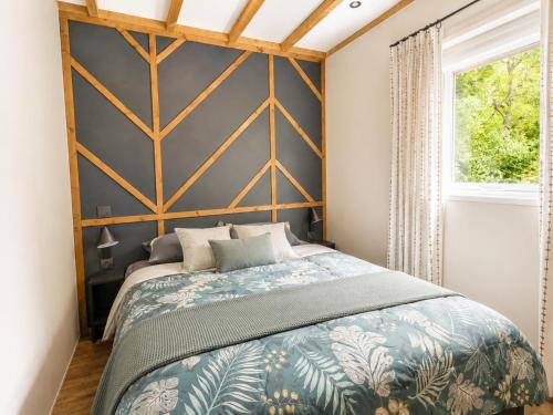 a bedroom with a large wooden headboard and a bed at Villages de Chalets et camping La Pierre de l'Aigle in La Bréole