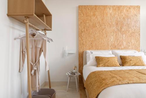 Schlafzimmer mit einem Bett mit einem Kopfteil aus Holz in der Unterkunft Halcyon Days designer apartments by Ana Locking in Málaga