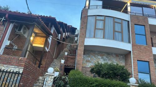 a brick house with a spiral staircase in front of it at Hotel Kappa3 Villas in Vlorë