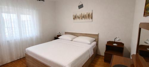 a bedroom with a white bed and a window at Apartment Nereo in Senj