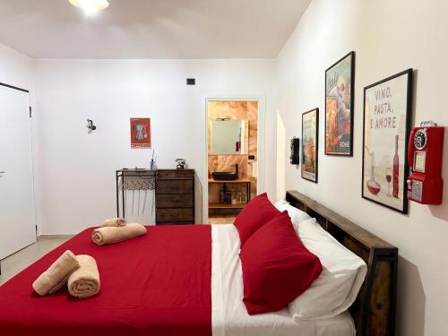 a bedroom with a red and white bed with two pillows at VaSaMi - Appartamento in centro in Bari