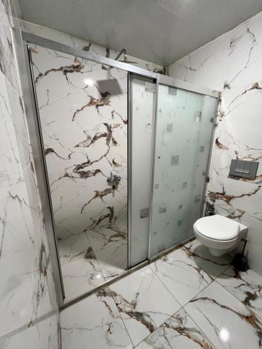 a bathroom with a glass shower and a toilet at Hotel Gazi in Gaziantep