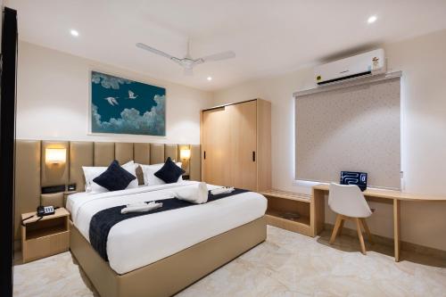 a bedroom with a large bed and a projection screen at ELYSIUM Premier Suites Hitec City in Hyderabad