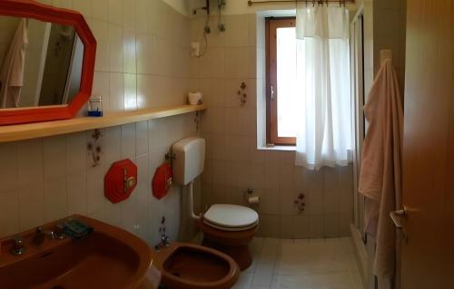 a bathroom with a toilet and a sink and a mirror at Casa Marel in Stromboli