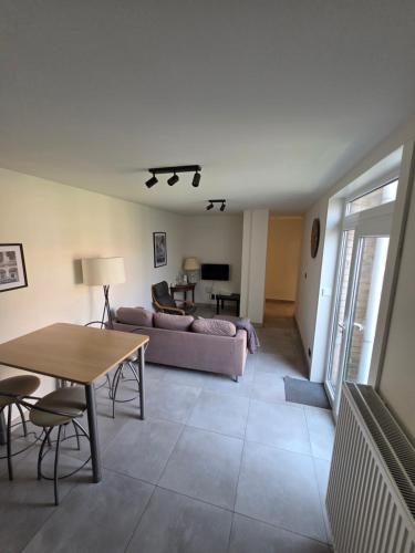a living room with a couch and a table at Duinenbank in Bredene
