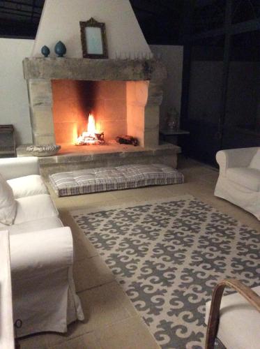 a living room with a fireplace and a white couch at Masseria Spartivento in Conca Specchiulla