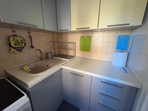 a small kitchen with white cabinets and a sink at Afytos Family Apartment in Afitos