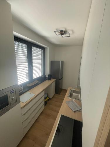 a small kitchen with a sink and a refrigerator at Apartmán Formula Trenčín in Trenčín
